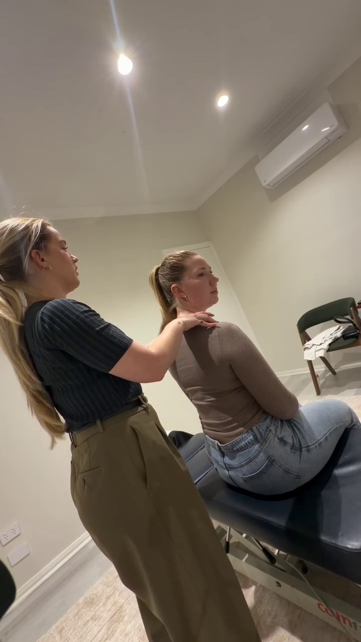 Dr. Brodie Kelly conducting physical cervical and posture assessment on patient